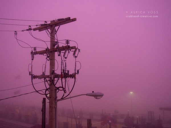Strommast im Nebel über dem Atlantik vor rosafarbenem Himmel
