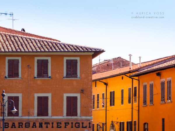 Orangefarbene Häuser in der Altstadt von Pisa im Sonnenlicht